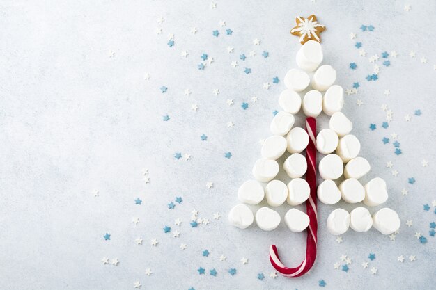 Caramelle gommosa e molle e lecca-lecca di Natale su fondo stellato