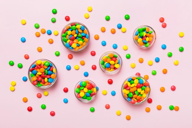 caramelle rotonde di colore diverso in una ciotola e vasetti Vista dall'alto di una grande varietà di dolci e caramelle con spazio per la copia
