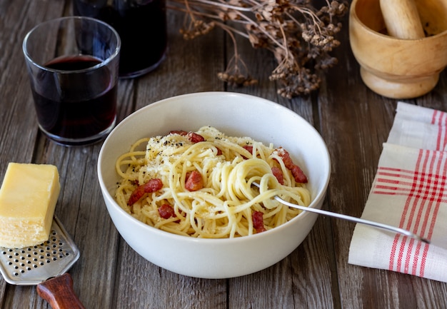 Carbonara degli spaghetti della pasta su una tavola di legno. Cucina italiana. Ricetta. Stile rustico. Vino.