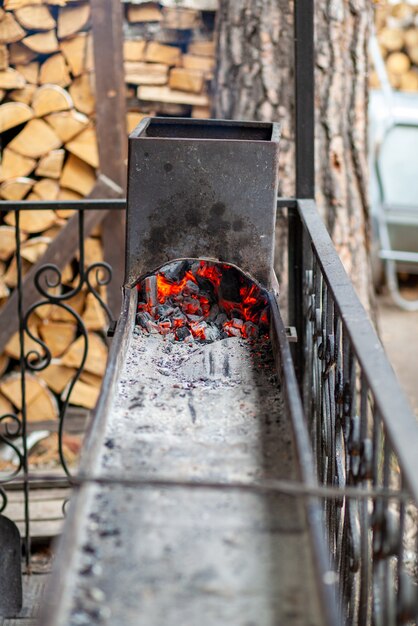 Carboni ardenti in una griglia metallica per friggere carne e verdure. Cucinare su un fuoco da campo.