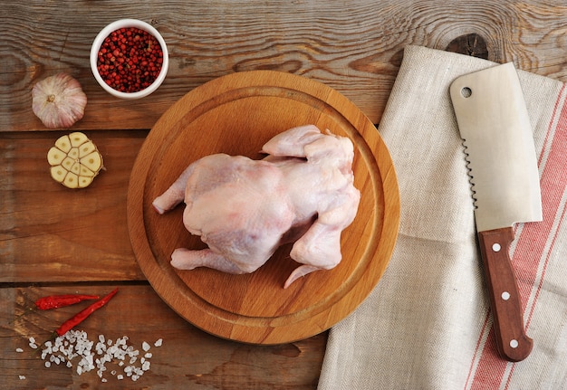 Carcassa di pollo crudo per rendere il pollo non una tavola di legno, un coltello, un machete