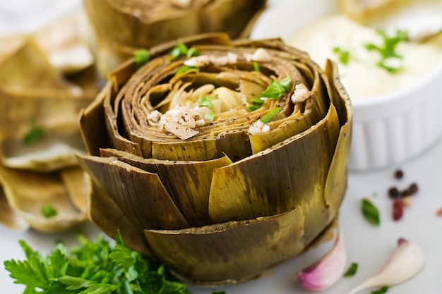 Carciofi al forno cucinati con salsa di aglio, senape e prezzemolo