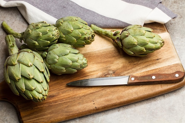 Carciofi crudi su una tavola di legno della cucina