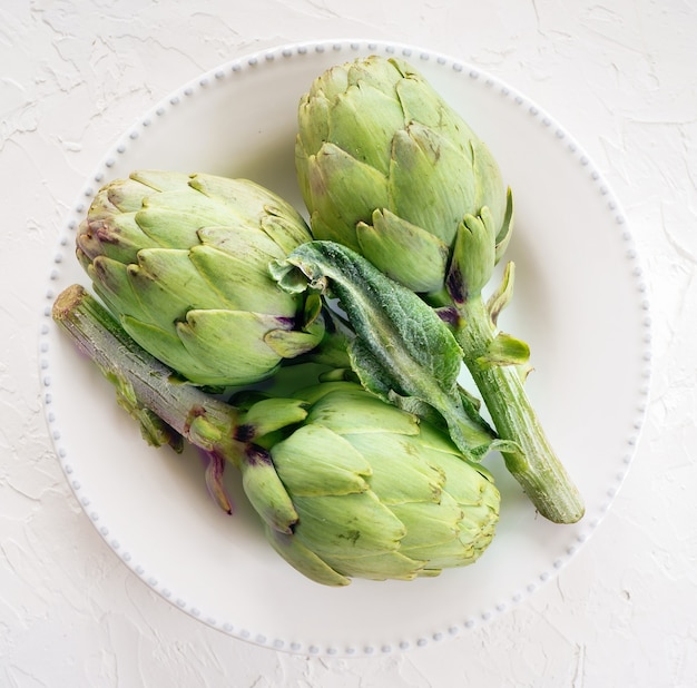 Carciofi freschi sulla piastra bianca, vista dall'alto