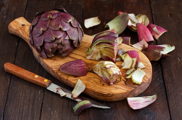 Carciofi romani su una tavola di legno con coltello