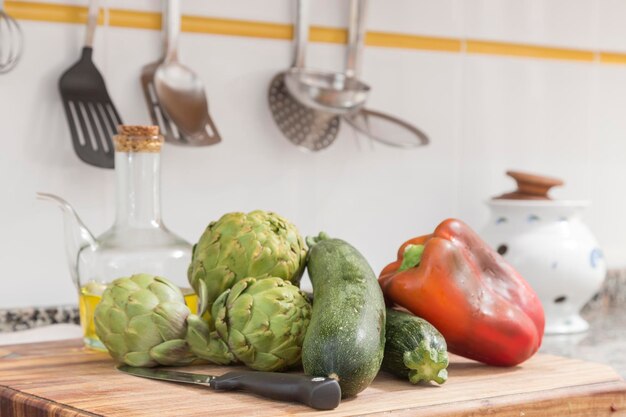 Carciofi zucchine pepe e olio sul tavolo della cucina cibo fresco