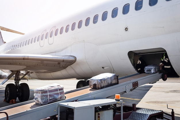 Caricamento dei bagagli sull'aereo Il bagaglio sul nastro trasportatore per l'aereo