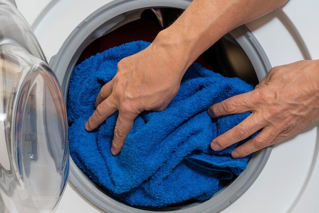 Caricamento della biancheria da letto in una lavatrice per uso domestico.