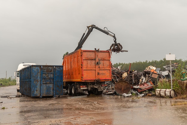 Carico di rottami metallici con gru idraulica, per il riciclaggio.