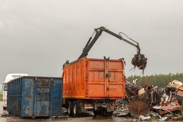 Carico di rottami metallici con gru idraulica, per il riciclaggio.