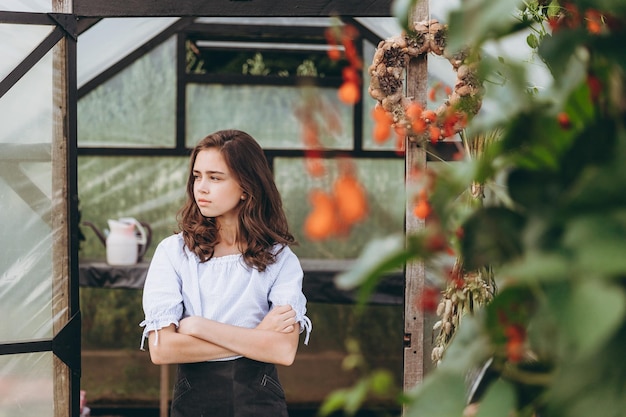 Carina bambina di 13 anni che porta cesto di bellissimi fiori nel campo dei fiori con felicità