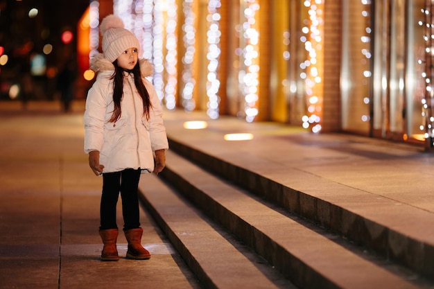 Carina bambina felice cammina per le strade di una grande città