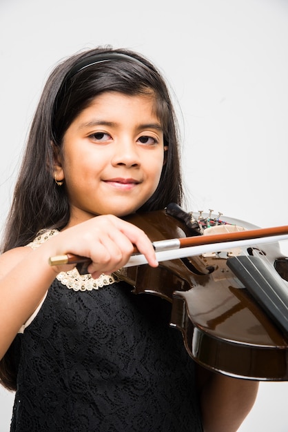 Carina bambina indiana o asiatica che suona il violino, isolata su sfondo bianco