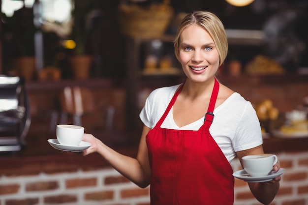 Carina cameriera con due tazze di caffè