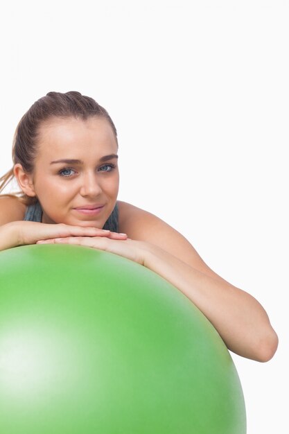 Carina donna sportiva sostenendosi con una palla fitness