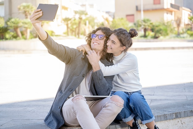 Carina giovane coppia mentre scatta una foto seduta per strada