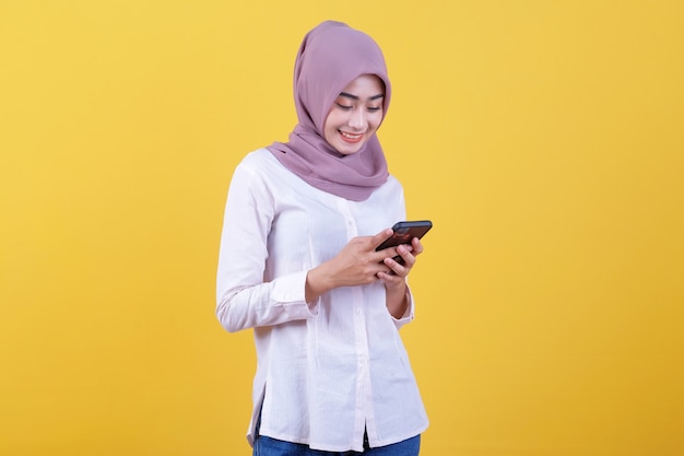 Carina giovane donna graziosa che chiacchiera al telefono cellulare indossando l'hijab