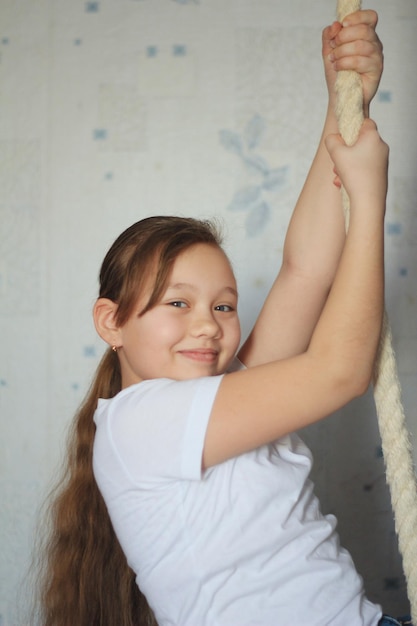 Carina ragazza adolescente di 12 anni in posa vicino a una corda da ginnastica, primo piano