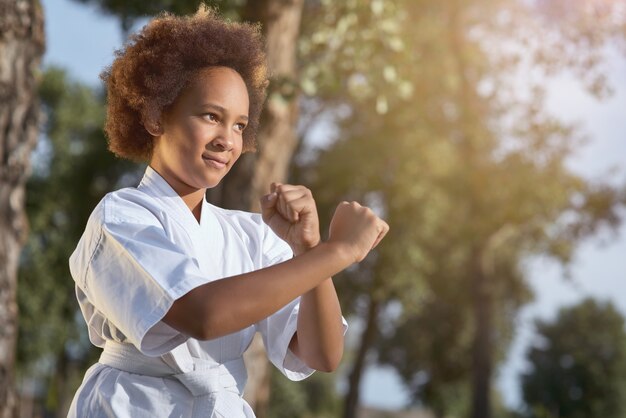 Carina ragazza afroamericana che pratica arti marziali in una giornata di sole nel parco