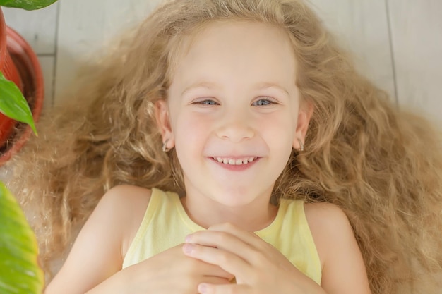 carina ragazza bionda felice con capelli ricci e occhi azzurri sorriso a trentadue denti