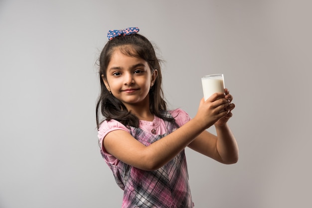 Carina ragazza indiana o asiatica con in mano un bicchiere pieno di latte - concetto di alimentazione sana