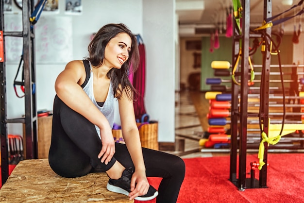 Carina ragazza sportiva che si siede in palestra