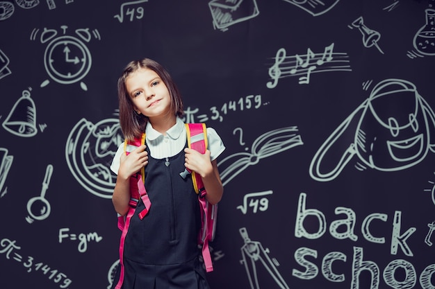 Carina studentessa caucasica che si prepara per andare a scuola con lo zaino resta davanti a scuola