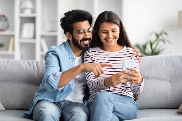 Carino amorevole coppia indiana utilizzando lo smartphone a casa