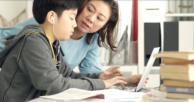 Carino asiatica madre aiutare tuo figlio a fare i compiti.