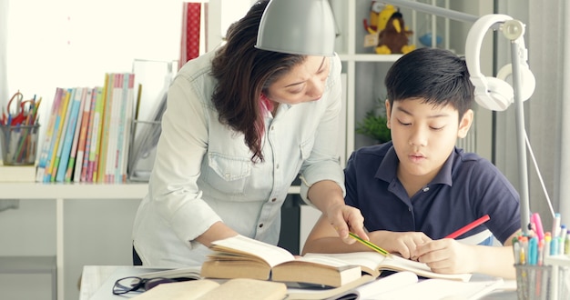 Carino asiatica madre aiutare tuo figlio a fare i compiti.