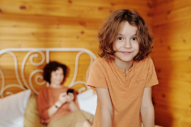 Carino bambino sorridente con i capelli biondi che indossa una maglietta che guarda l'obbiettivo