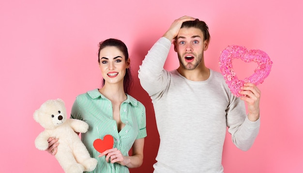 Carino concetto regalo San Valentino e amore Uomo e donna coppia innamorata tenere cuore biglietti di San Valentino e orsacchiotto su sfondo rosa Uomo bello e bella ragazza innamorata Coppia romantica innamorata