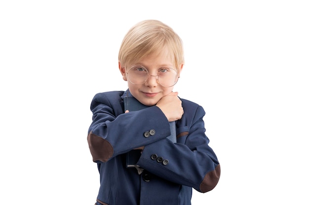 Carino firstgrader in uniforme scolastica e occhiali abbracci libro Ritratto di scolaro con libro Isolamento su sfondo bianco