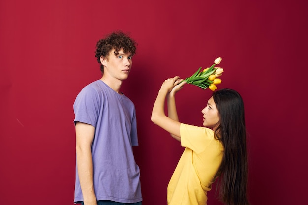 Carino giovane coppia regalo bouquet di fiori divertimento sfondo rosso inalterato