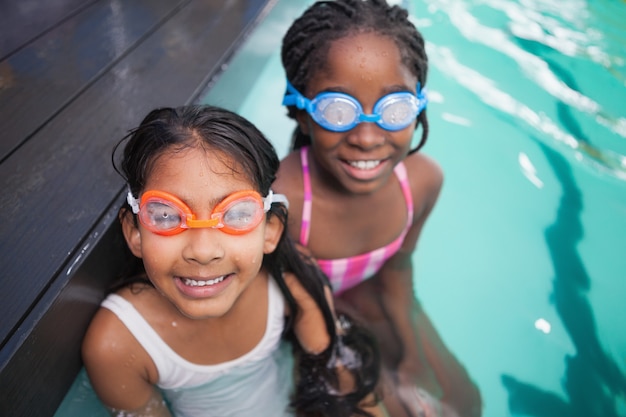 Carino piccoli bambini seduti a bordo piscina