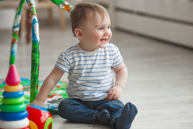 Carino piccolo bambino che gioca al chiuso. Neonato abbastanza infantile