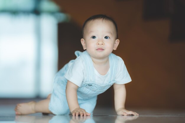 Carino piccolo bambino che prova e impara a gattonare a casa