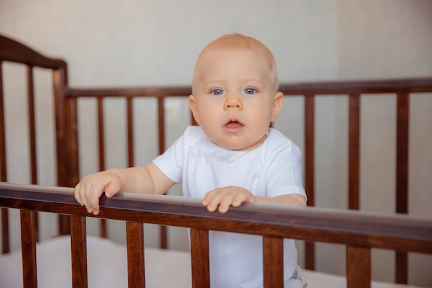 Carino piccolo neonato è seduto in una culla il neonato è seduto nella culla sorridente