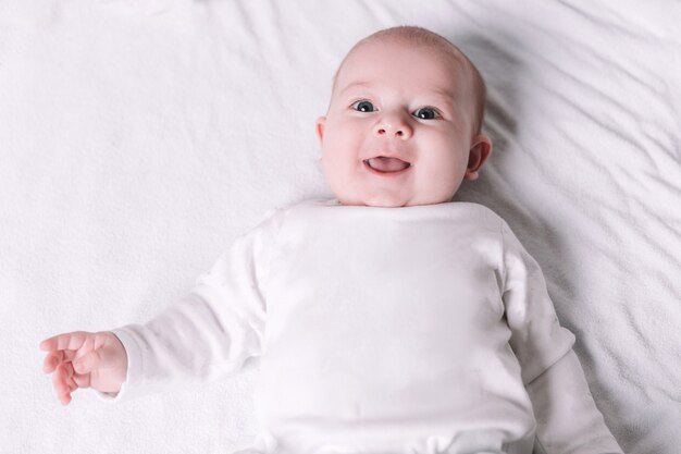 carino sorridente bambino sdraiato sul letto. il concetto di felicità