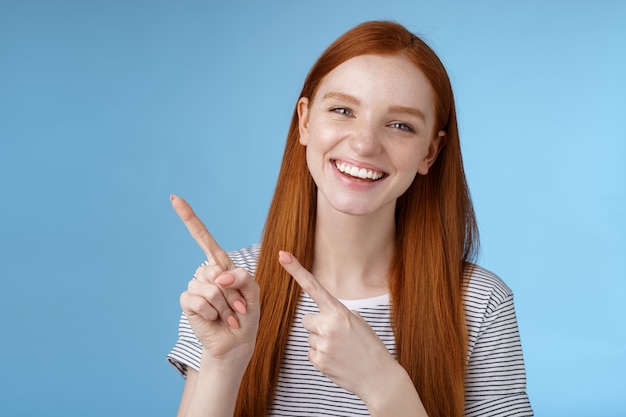 Carismatica amichevole bella rossa ragazza in uscita uscire con gli amici che mostrano un buon posto sedersi godetevi il pasto che punta nell'angolo in alto a sinistra sorridendo ridendo felicemente divertitevi consiglia promo, pubblicità.