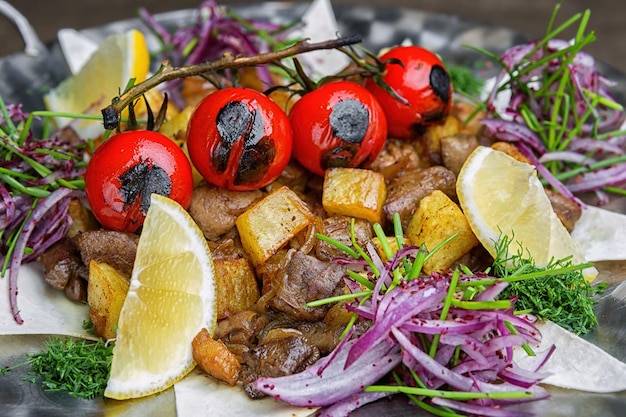 Carne a cottura lenta con patate ai funghi e pomodori grigliati