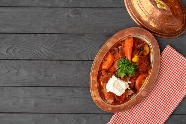 Carne al vapore con verdure in salsa di pomodoro su legno