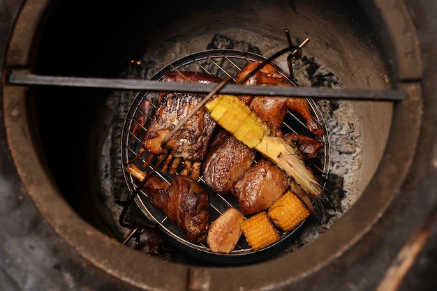 Carne arrostita deliziosa assortita con le verdure sopra i carboni su un barbecue