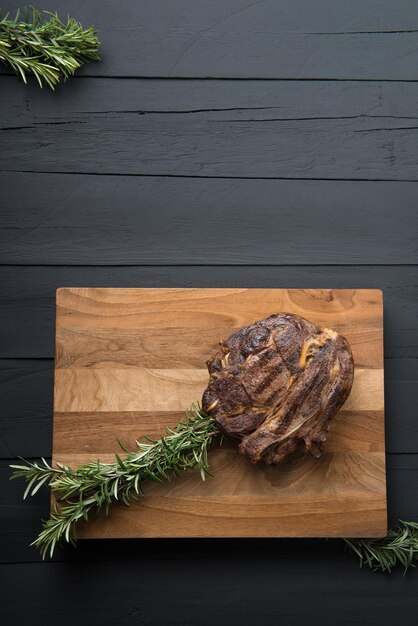 Carne arrostita su un tagliere su un fondo di legno nero