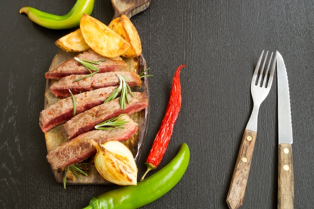 Carne arrosto media alla griglia. su sfondo nero.