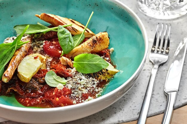 Carne con patate e verdure servite su un tavolo di legno