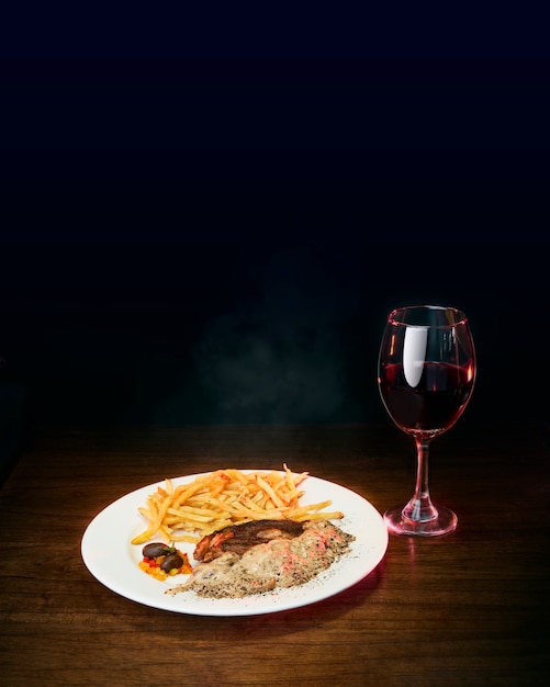 Carne con patatine fritte e vino