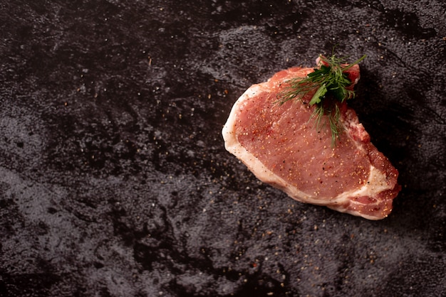 Carne cruda, bistecca di manzo su fondo nero, vista superiore