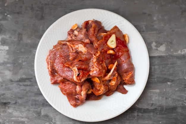 Carne cruda con erbe aromatiche e aglio per grigliare sul piatto