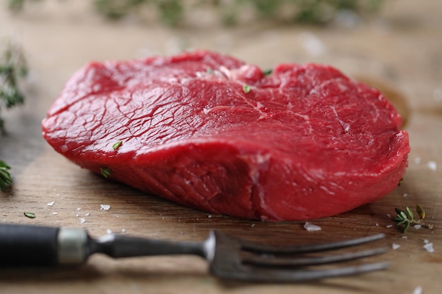 Carne cruda con spezie, erbe e sale pronta per la cottura sul tavolo Primo piano